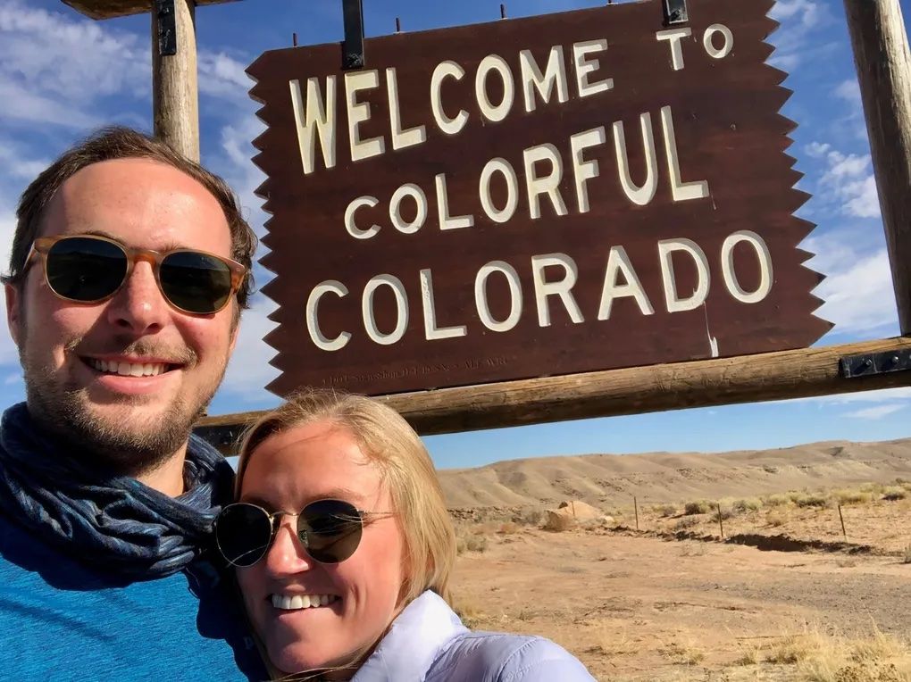 a couple standing in front of a colorado sign