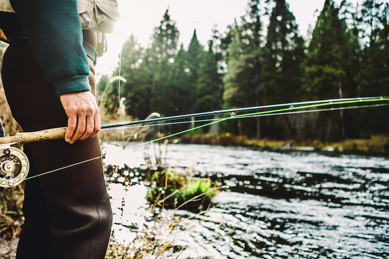 man carrying fly fishing rod