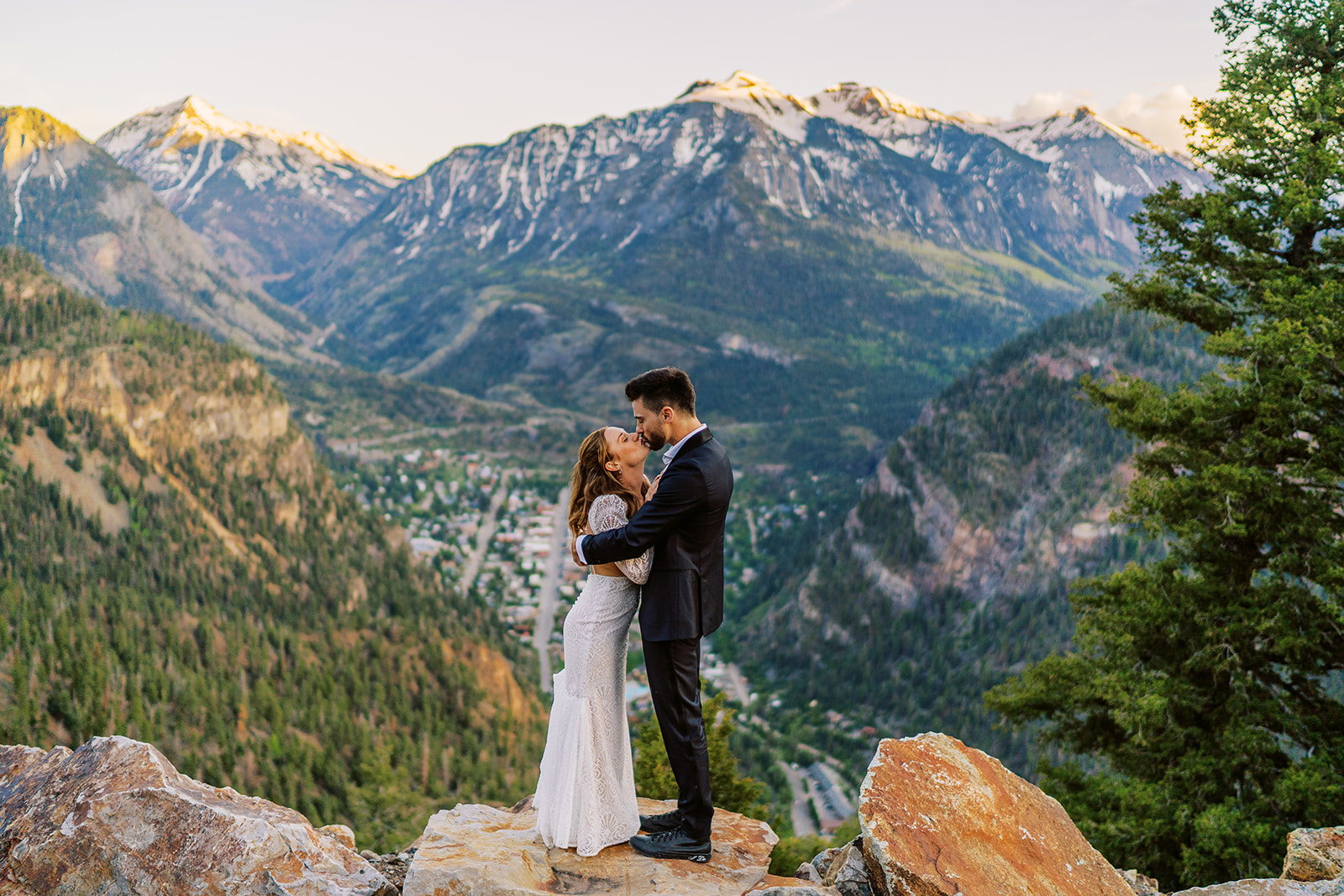 bride and groom kiss looking over a town