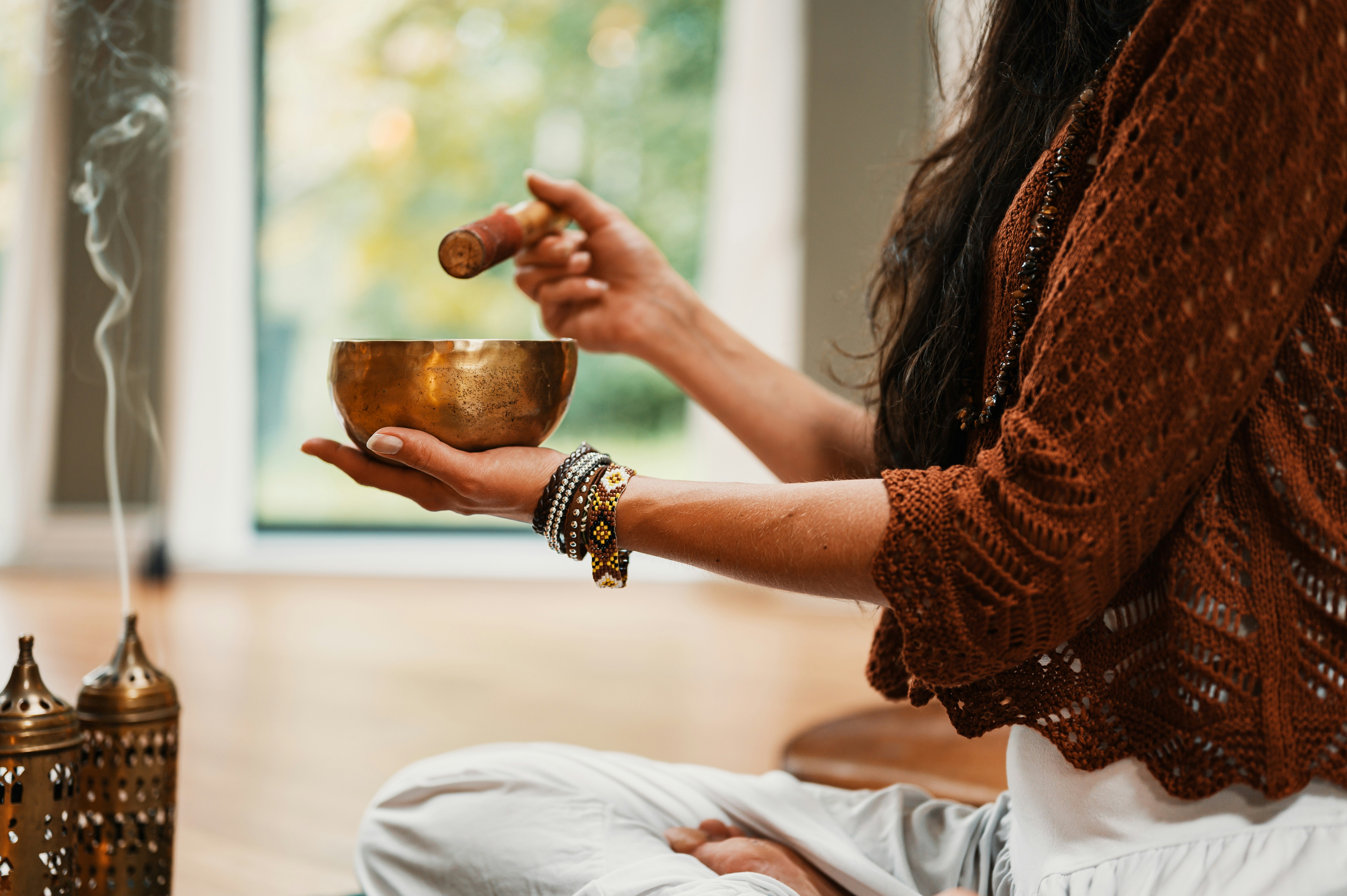 woman with sound bowl in hand and insense burning