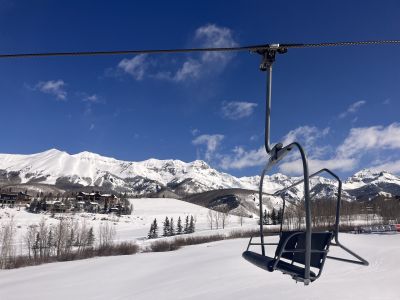 chair lift with snowy mountains in background