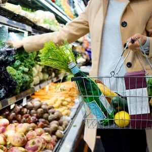 woman shopping for produce holding basket