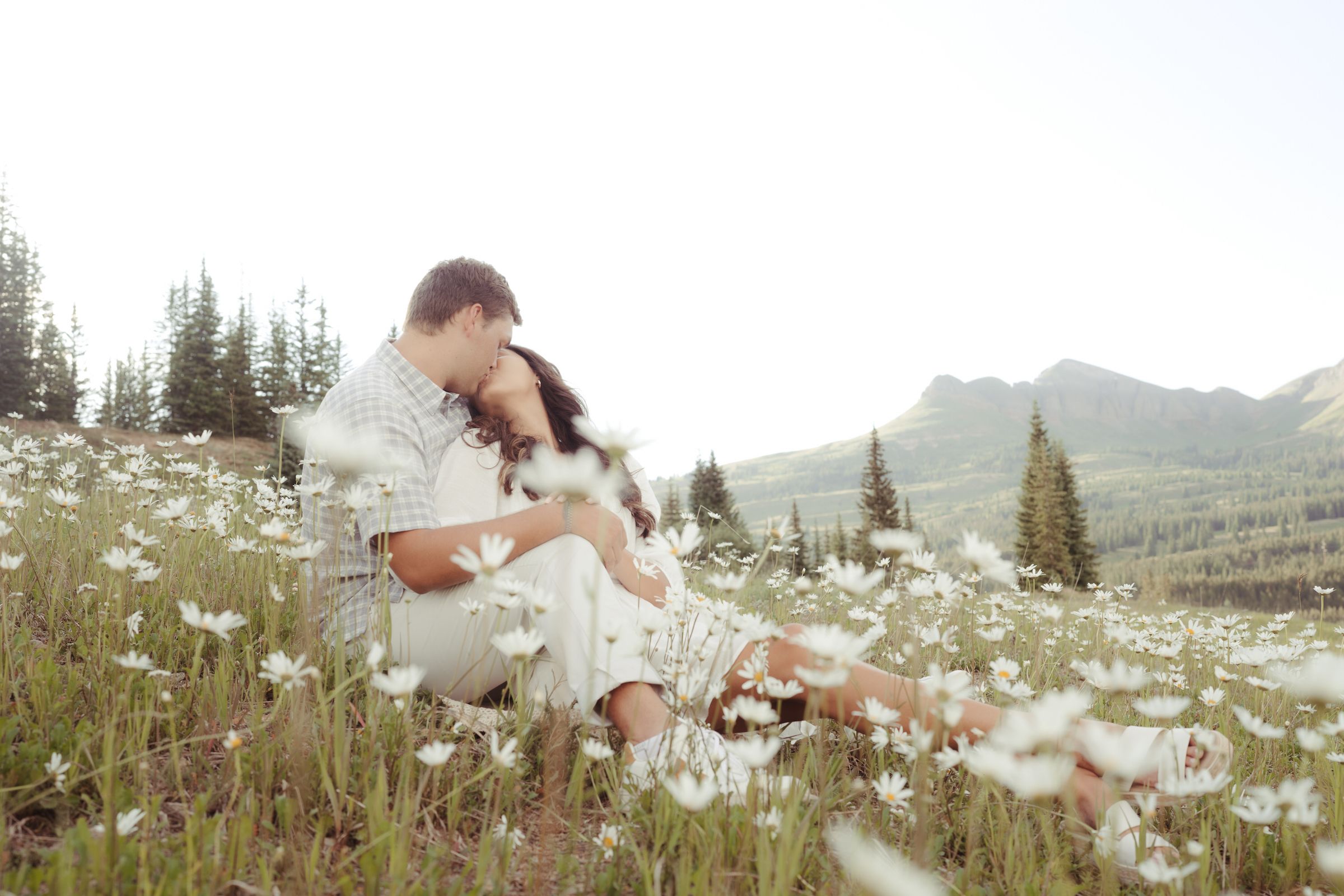 Couple kissing in a field of daisies