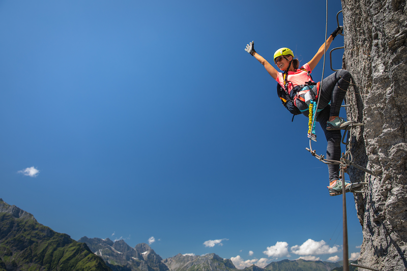 woman climbing a rock face